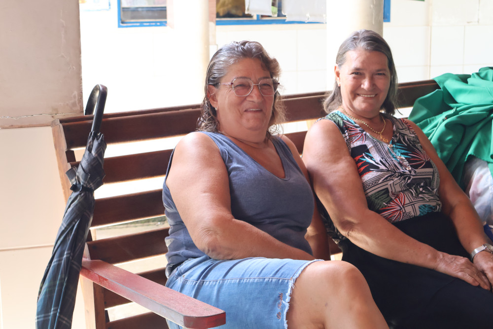 Duas mulheres já de idade sorrindo sentadas juntas